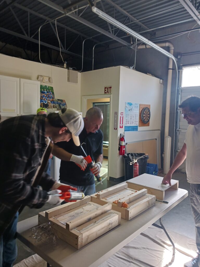 Group of people learning how to use a caulk gun